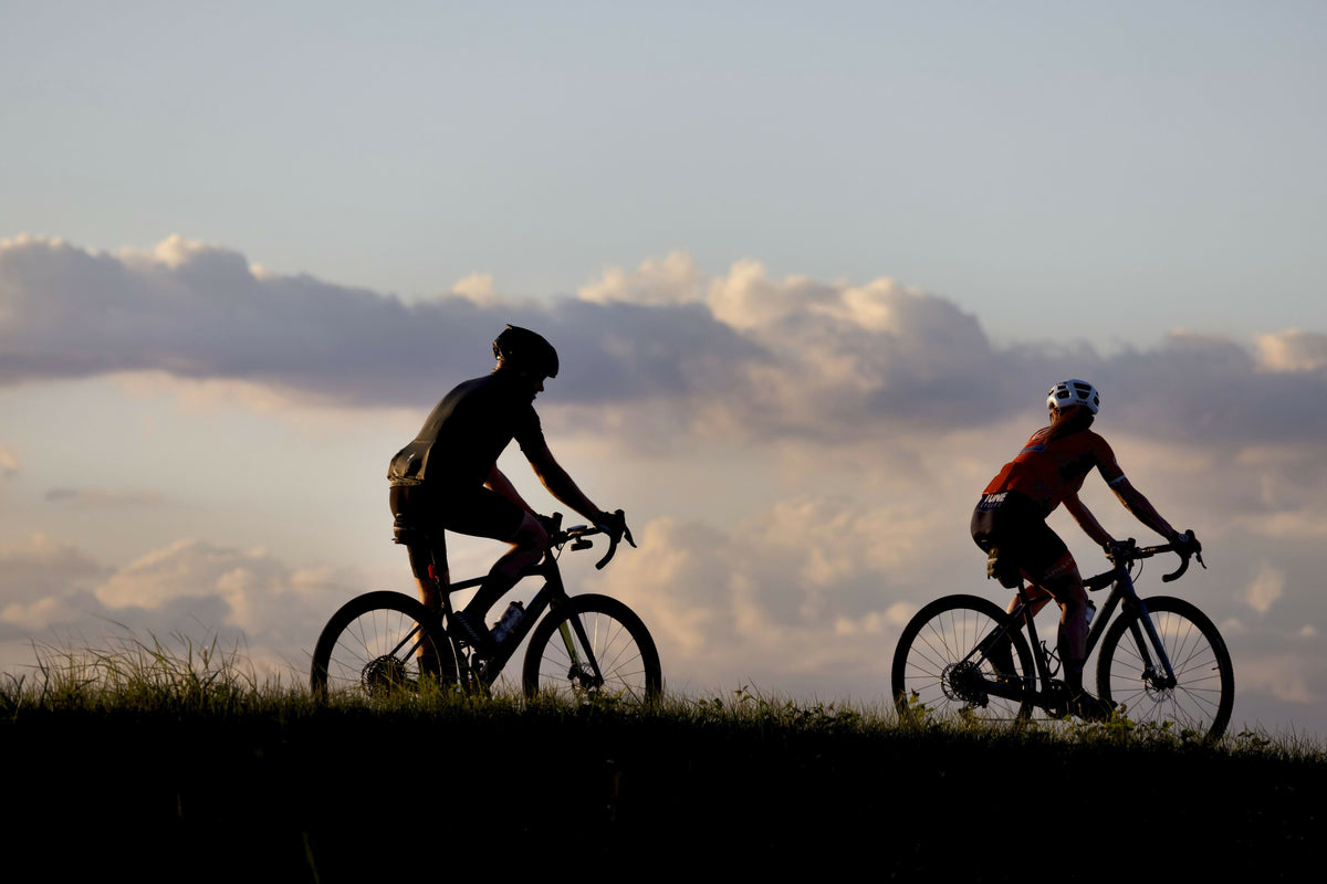 Two Cyclists Silhouetted at Sunset