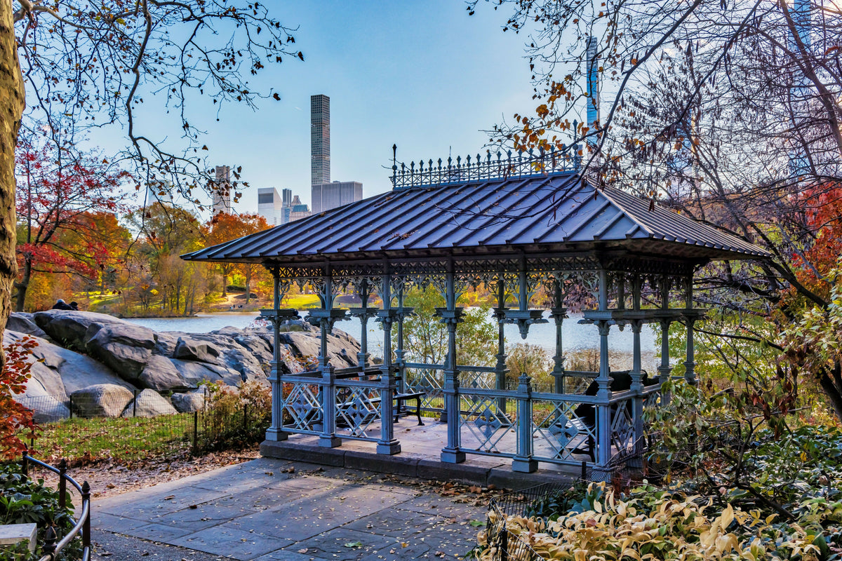 USA, New York City, Manhattan, Central Park, Ladies Pavilion Overlooking the Lake with Autumn Foliage, Rock Formations, and the Midtown Skyline in the Background