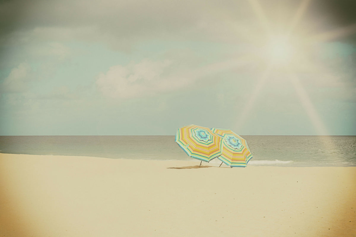 Two Colorful Beach Umbrellas on an Empty Beach
