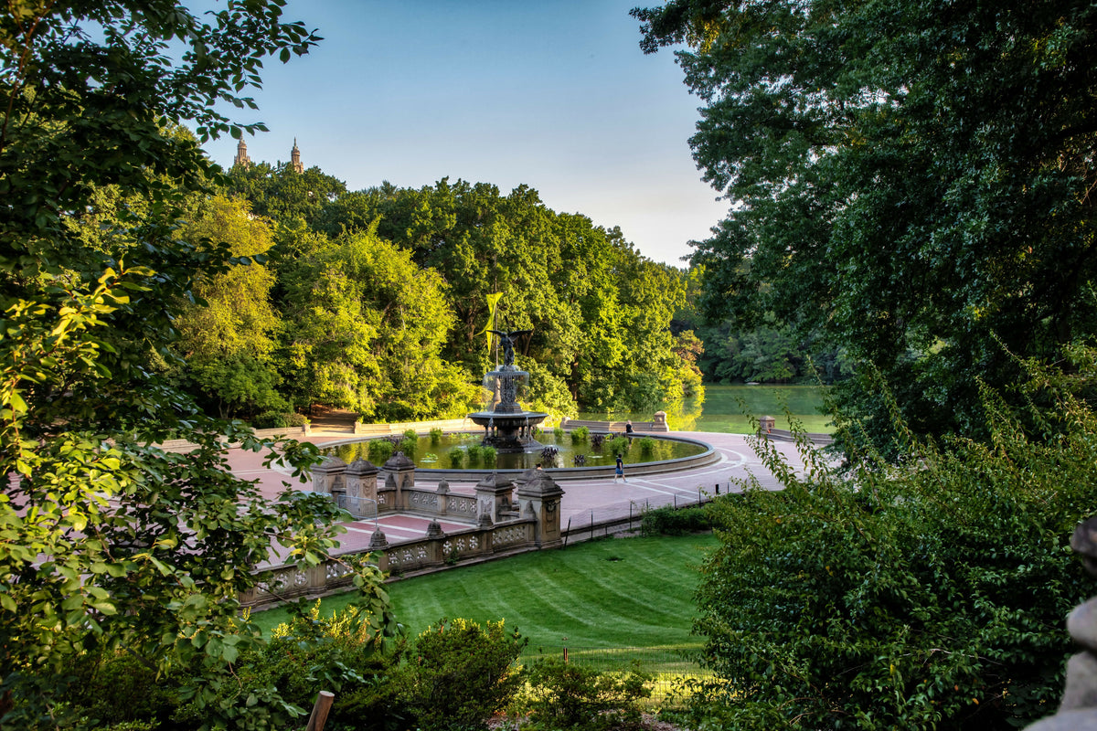 USA, New York City, Manhattan, Central Park, Bethesda Fountain and Terrace Viewed Through Lush Summer Greenery, with the Lake and the San Remo Towers in the Distance