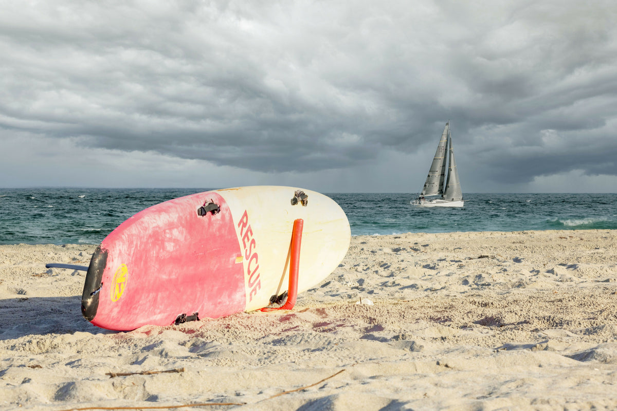 Beach with Sailboat and Surfboard
